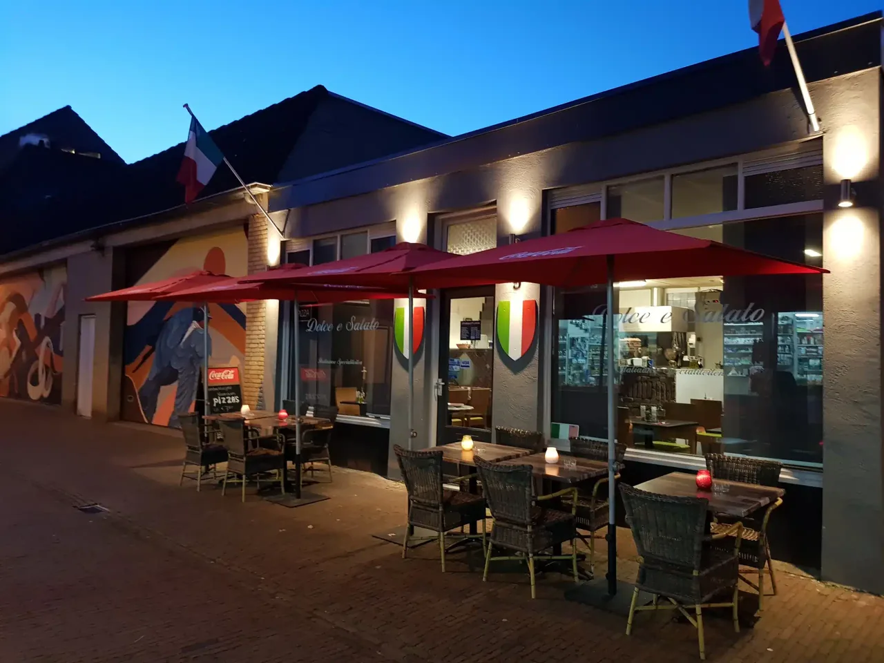 Het verlichte terras en de gevel van Dolce e Salato in Breda in de avond